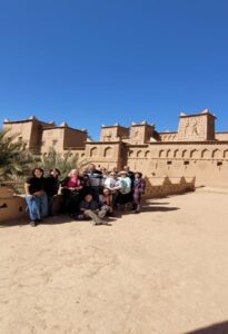 a group posing for a picture in front of an old building 