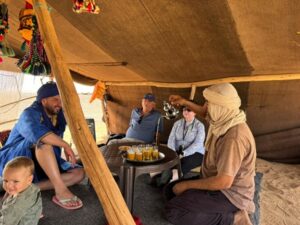 people sitting together inside a tent and having tea 