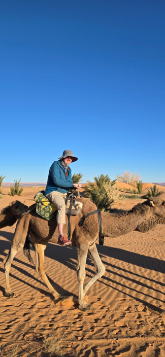 A tourist riding a camel in a desert