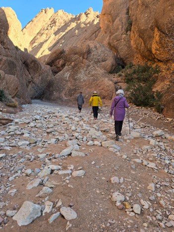 people walking up the rocky mountain in a line