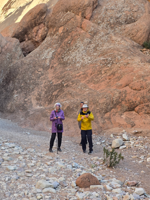 A mountain guide leads hikers along a scenic ridge in the High Atlas Mountains of Morocco.