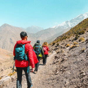 a group of three people walking through the hills