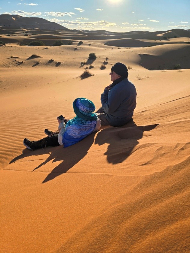 Two people sitting in a desert