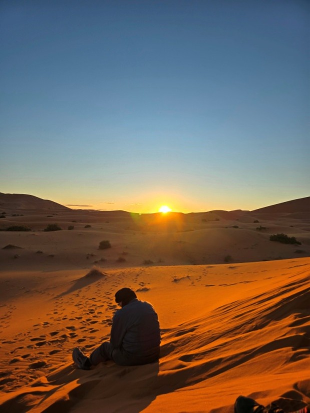 A tourist enjoying the Sunset in a desert