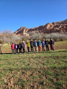A group of tourists posing for a picture in front of a mountain