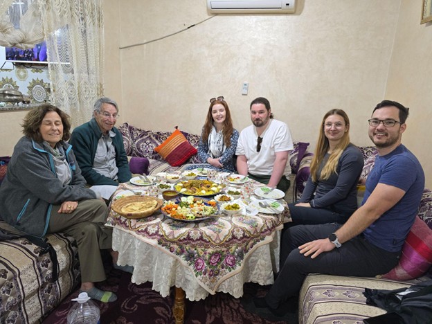 People gathered around a table eating Moroccan food 