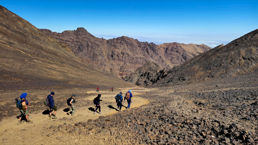 Group of hikers descending a rocky trail.