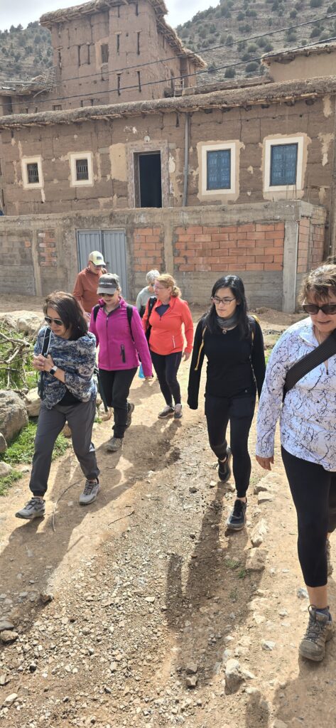 Travelers hiking through an Atlas Mountain village in Morocco.