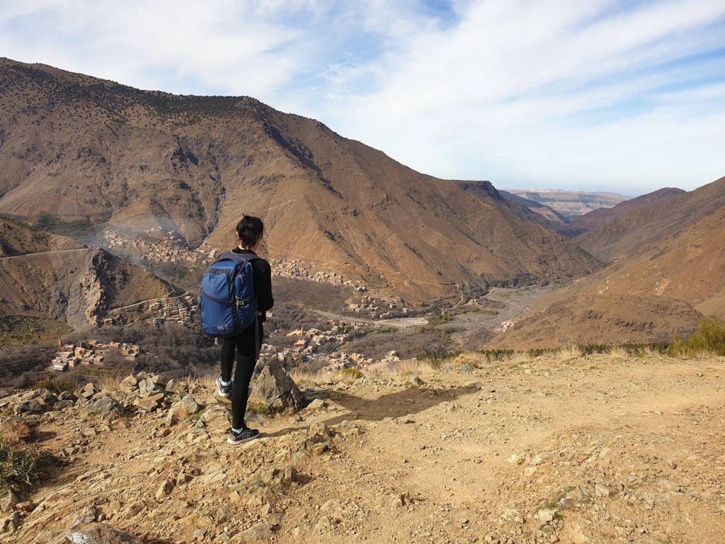 A traveler enjoying a panoramic view of the Atlas Mountains.
