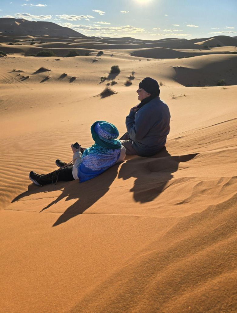 Two people sitting on the desert sand